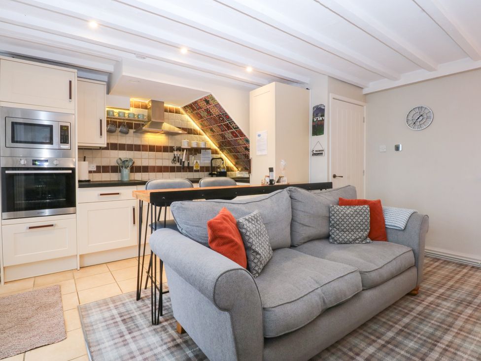 A kitchen with a sofa and kitchenette at Pine Cottage Dinas Dinlle