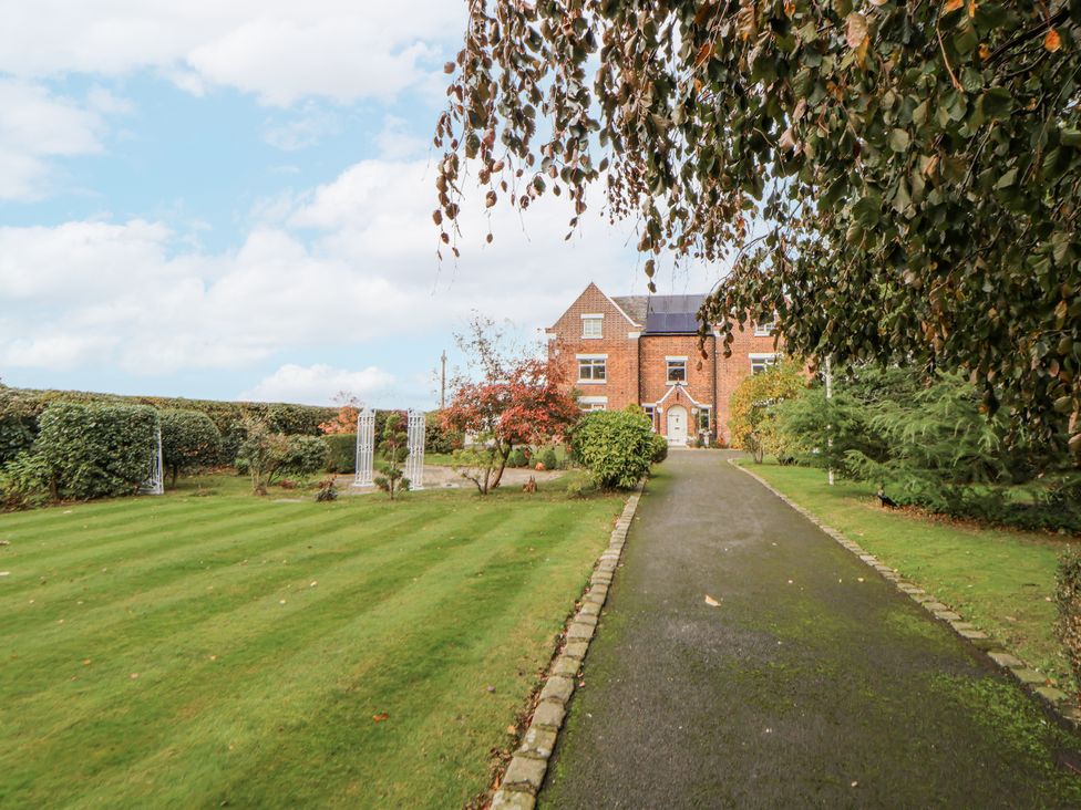 An outdoor area with a house and garden at The House at School Farm in Hassall near Haslington