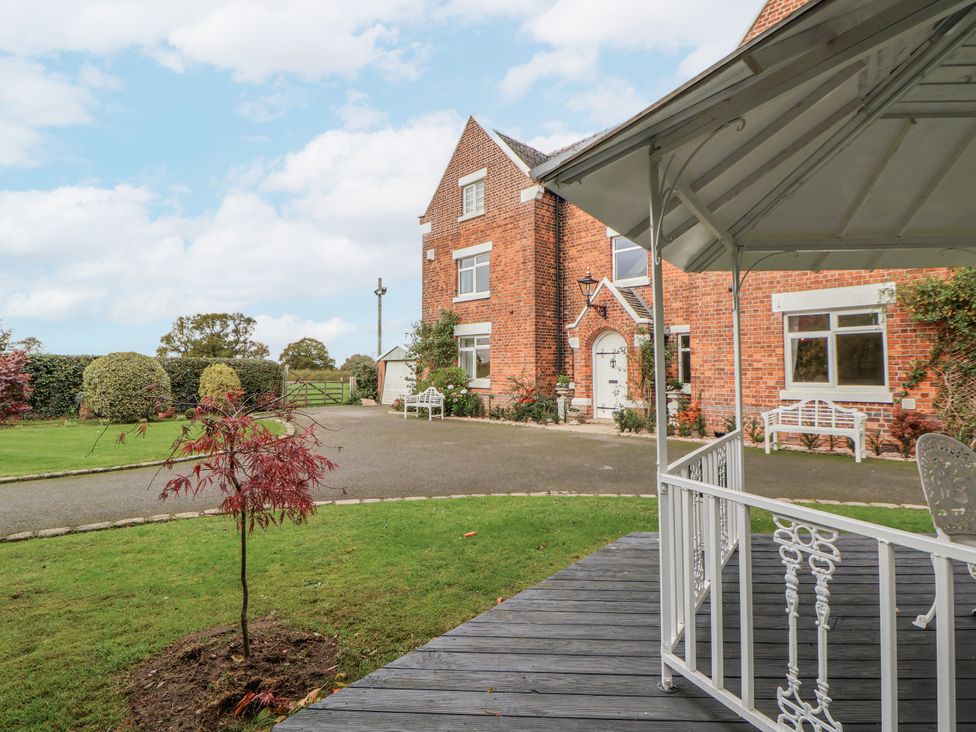 A garden with a house and seating area at The House at School Farm Hassall near Haslington