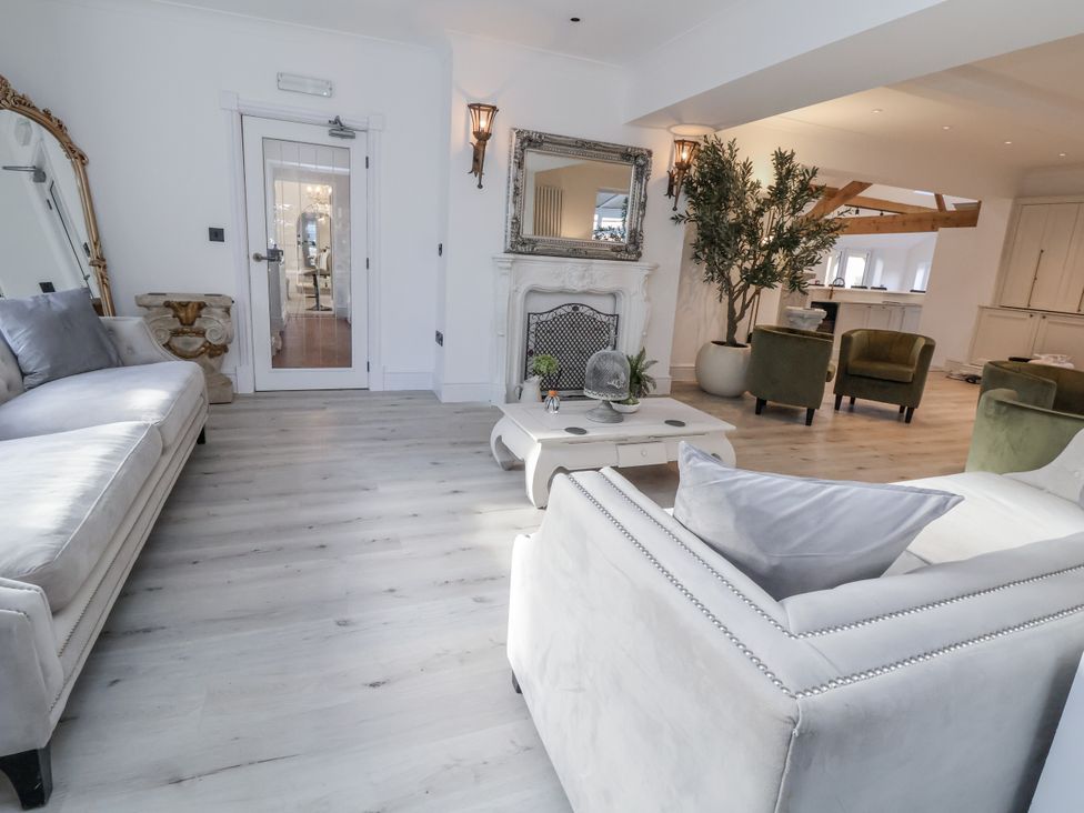 A living room with a fireplace and seating area at The House at School Farm in Hassall near Haslington
