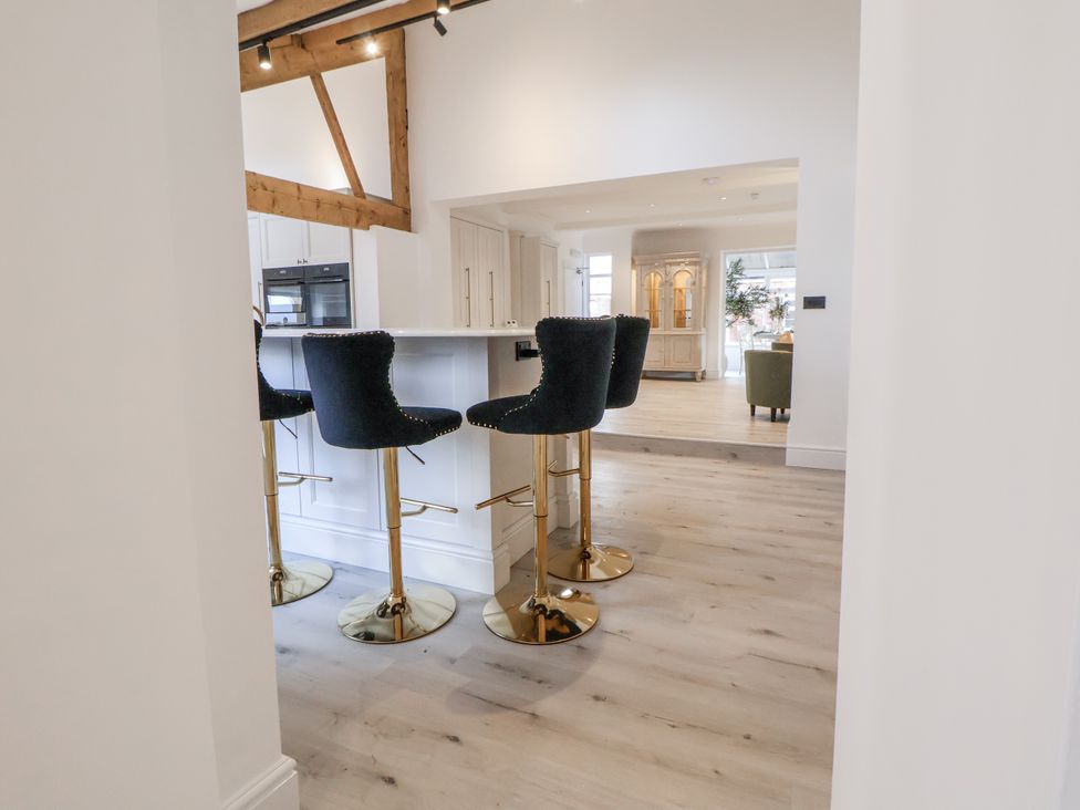 A kitchen with bar stools at The House at School Farm in Hassall near Haslington