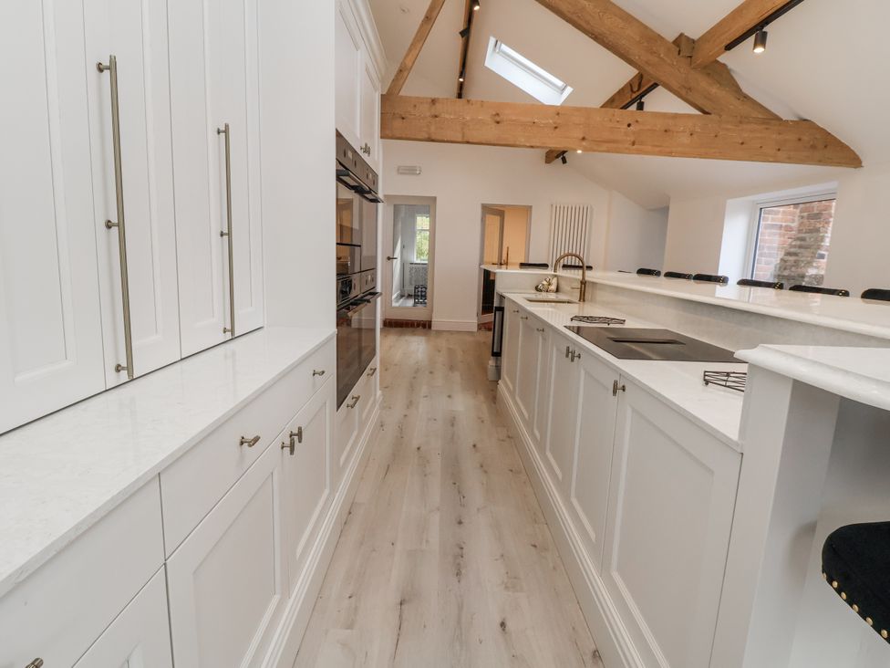 A kitchen with white cabinets and countertop at The House at School Farm in Hassall near Haslington
