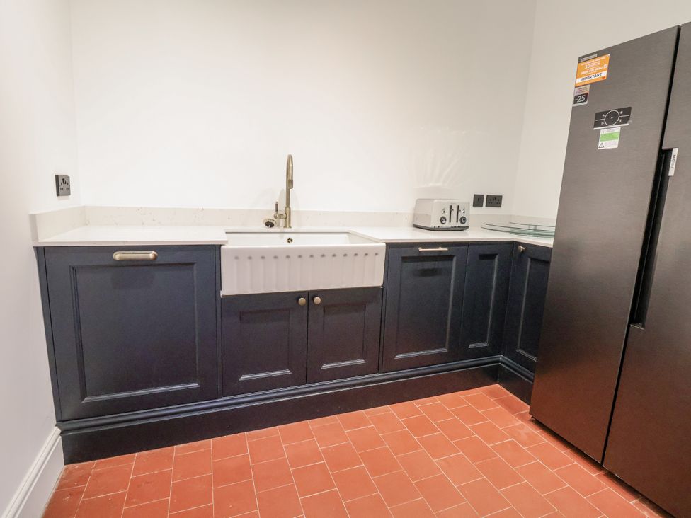 A kitchen with a sink and refrigerator at The House at School Farm in Hassall near Haslington