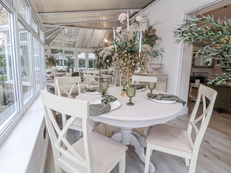 A dining room with a round table and chairs at The House at School Farm in Hassall near Haslington