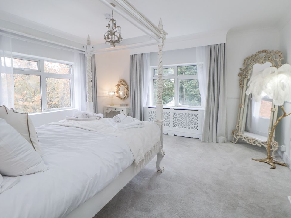 A bedroom with a four-poster bed and a mirror at The House at School Farm Hassall near Haslington