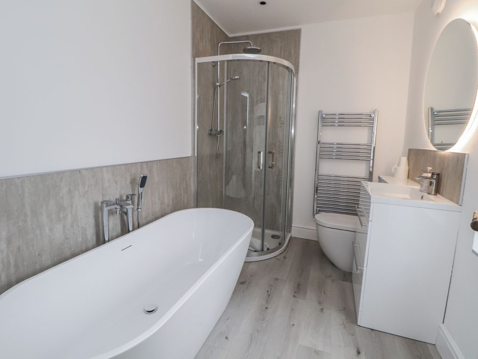 A bathroom with a bathtub, shower, toilet, and sink at The House at School Farm in Hassall near Haslington