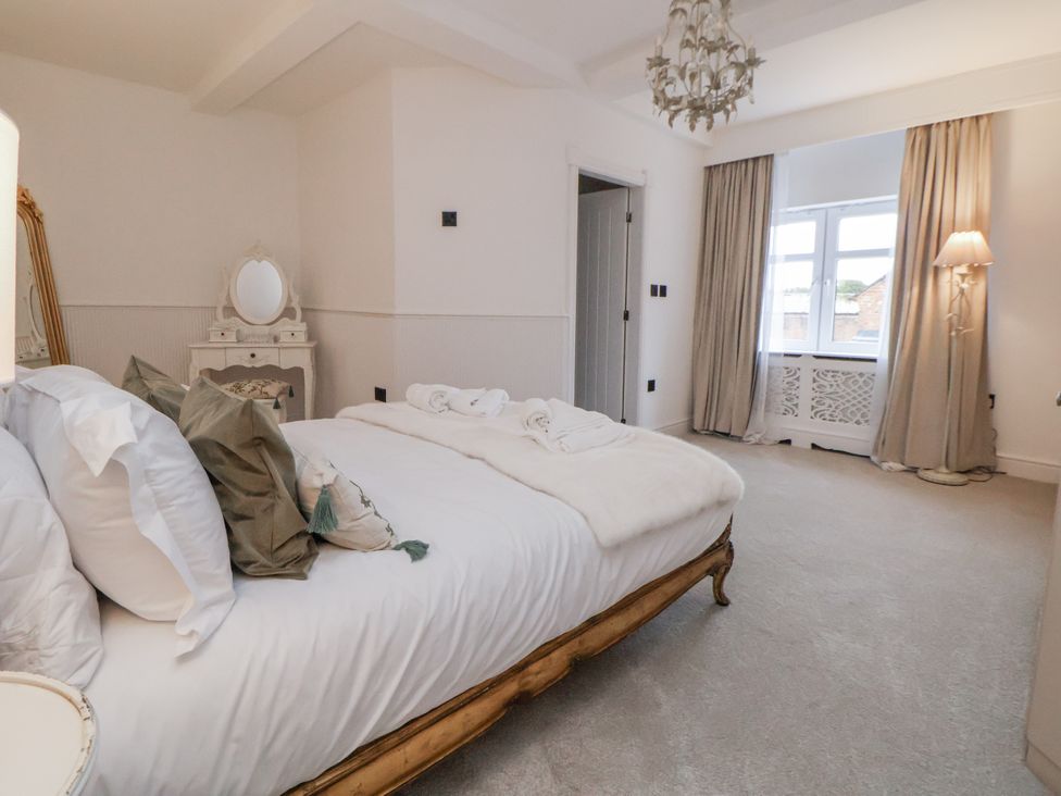 A bedroom with a bed and dressing table at The House at School Farm in Hassall near Haslington