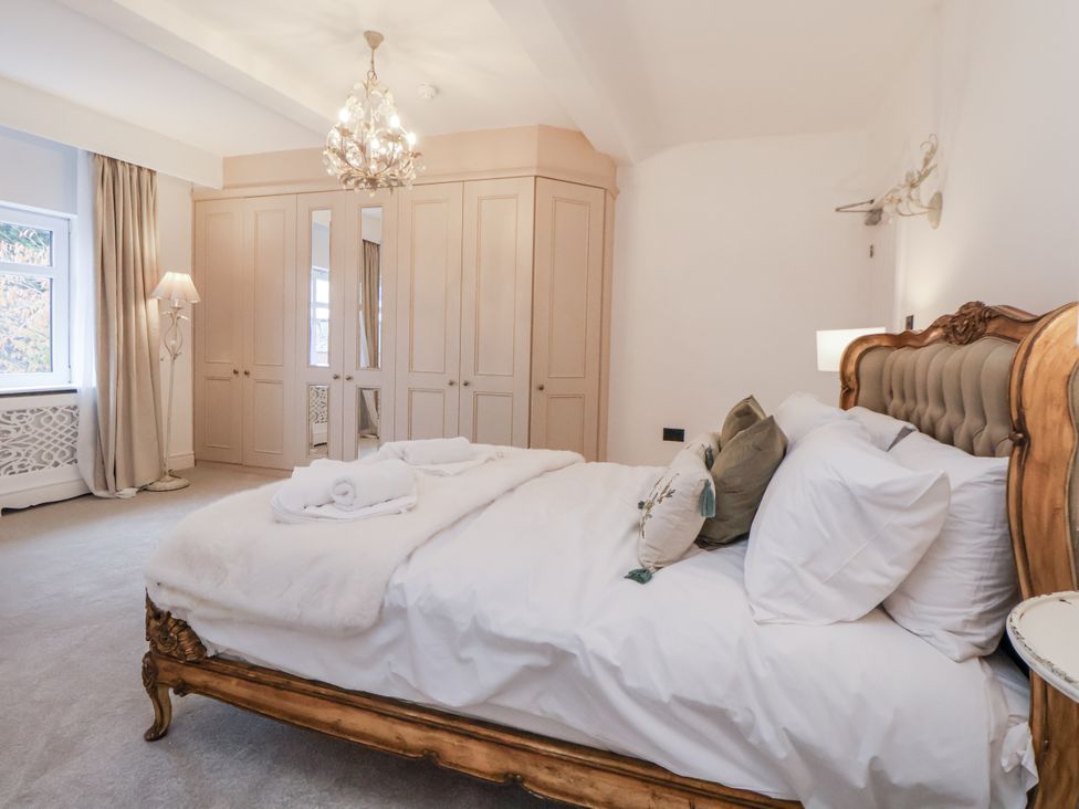 A bedroom with a bed and wardrobe at The House at School Farm in Hassall near Haslington