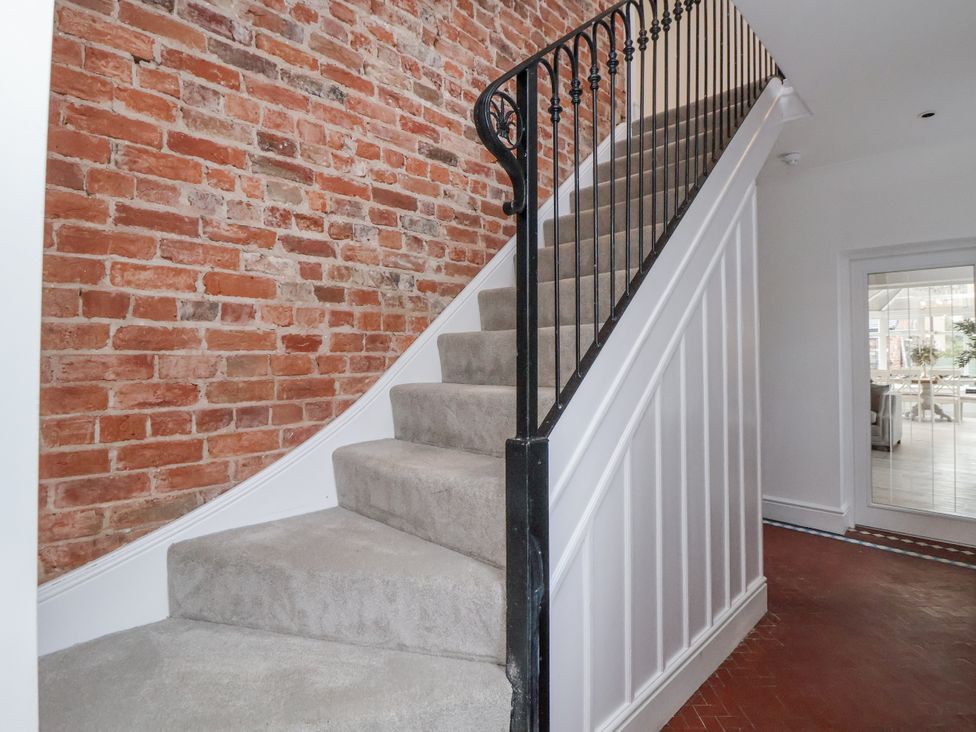 A staircase with a brick wall and a handrail at The House at School Farm in Hassall near Haslington