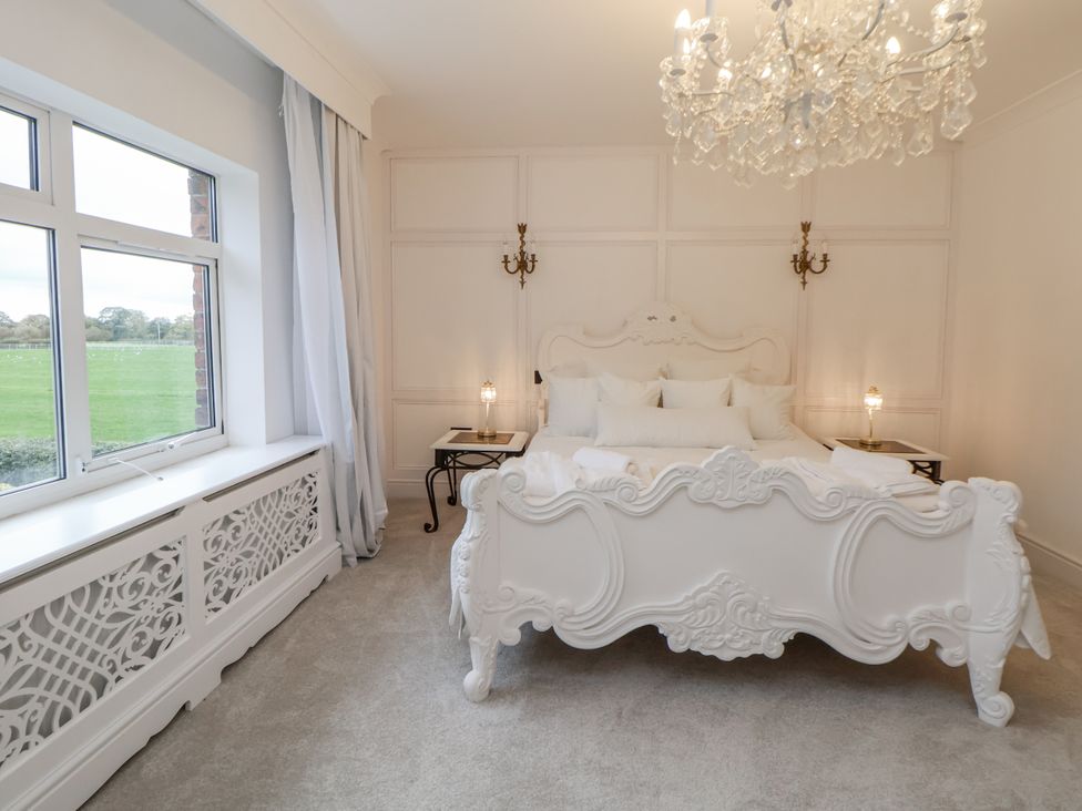 A bedroom with a bed and nightstands at The House at School Farm in Hassall near Haslington