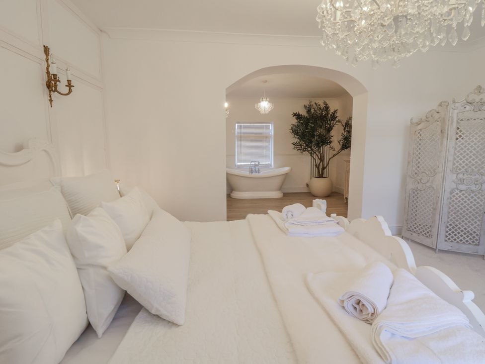 A bedroom with a bed and bathtub visible at The House at School Farm in Hassall near Haslington