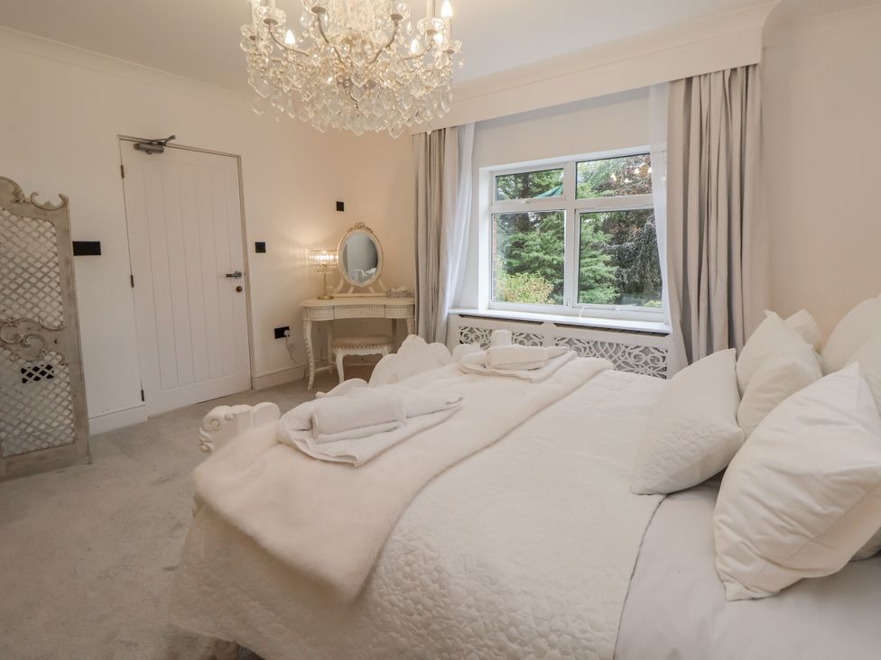 A bedroom with a bed and mirror at The House at School Farm in Hassall near Haslington