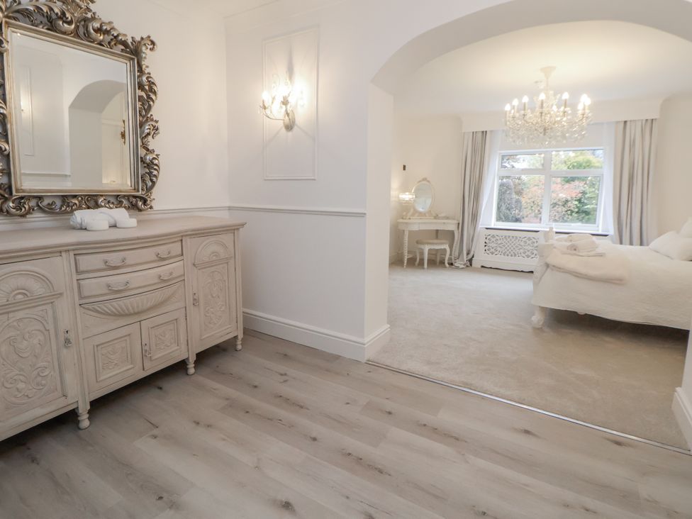 A bedroom with a cabinet and a mirror at The House at School Farm Hassall near Haslington