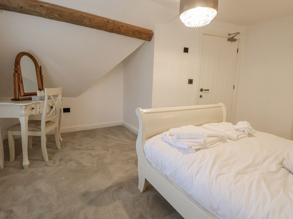 A bedroom with a bed and dressing table at The House at School Farm in Hassall near Haslington
