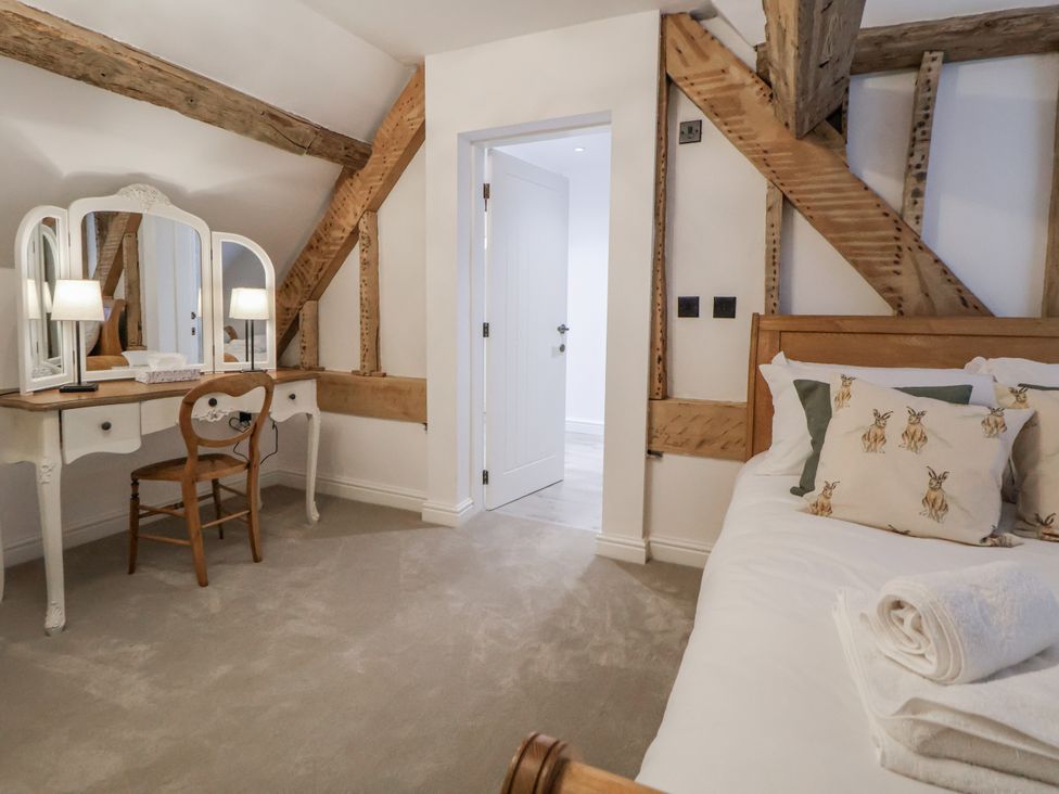 A bedroom with a bed and vanity at The House at School Farm Hassall near Haslington