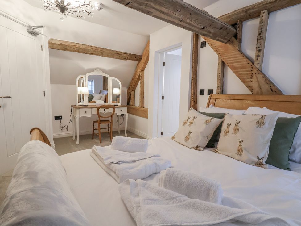 A bedroom with a bed and vanity table at The House at School Farm in Hassall near Haslington