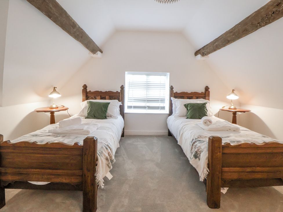 A bedroom with two beds and a window at The House at School Farm Hassall near Haslington