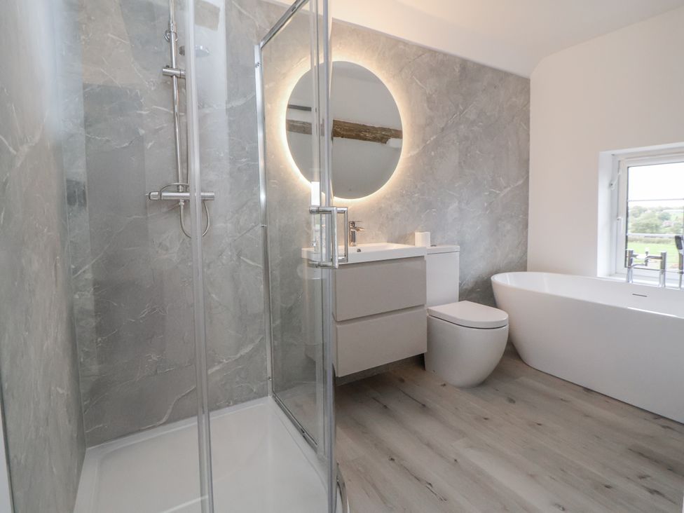 A bathroom with a shower toilet and bathtub at The House at School Farm in Hassall near Haslington