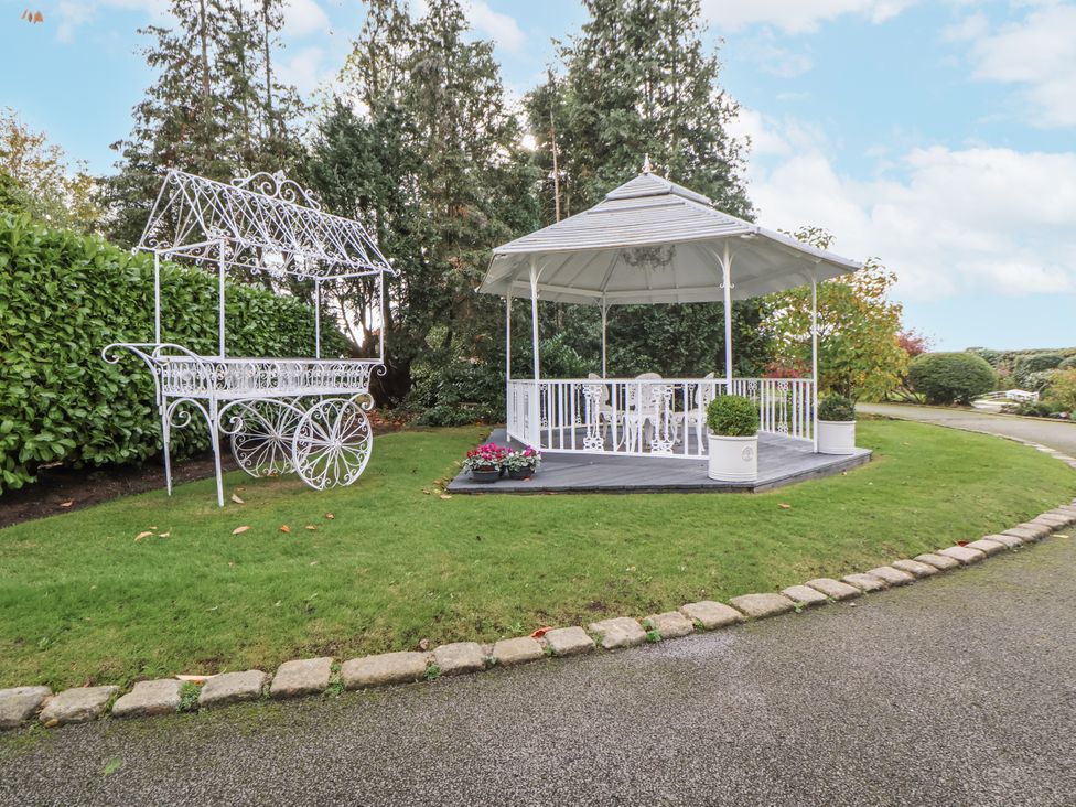 A gazebo with chairs and a decorative cart at The House at School Farm in Hassall near Haslington