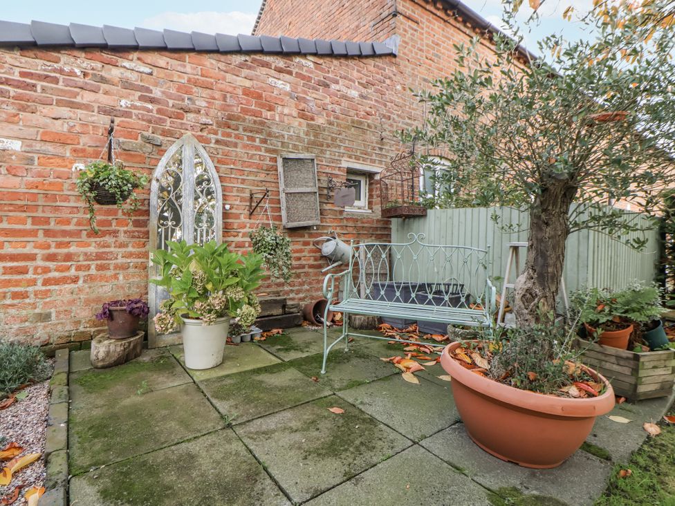 A garden with a bench and flower pots at The House at School Farm Hassall near Haslington