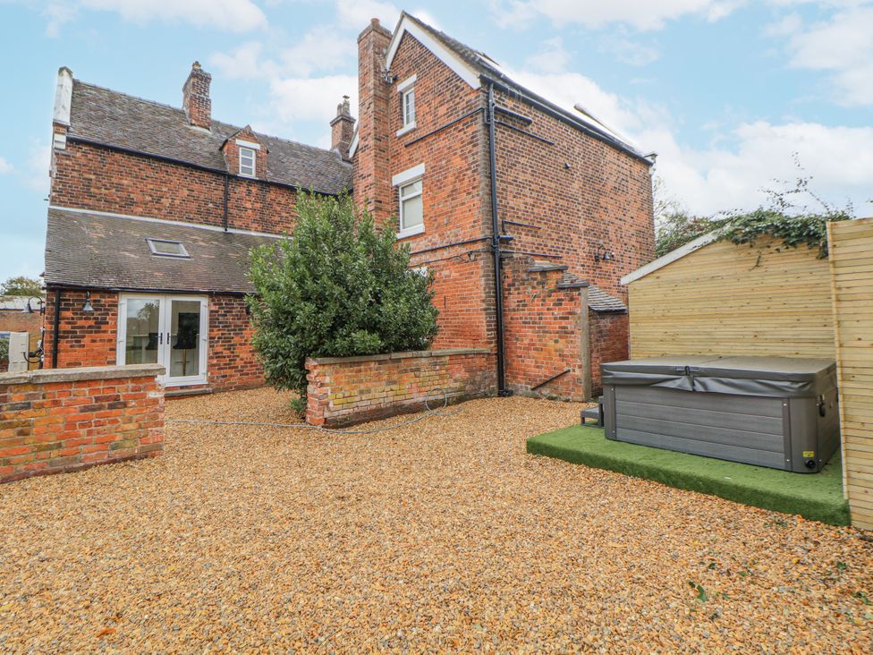 A garden with gravel and a hot tub at The House at School Farm in Hassall near Haslington