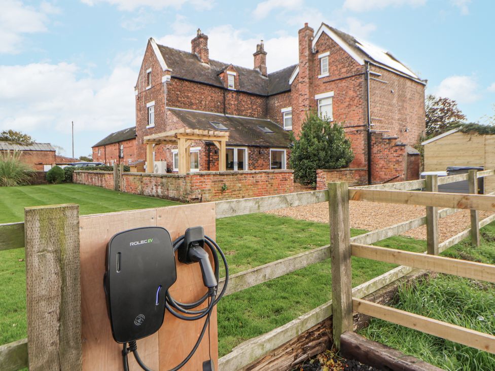An outdoor view of a house with a charging station at The House at School Farm Hassall near Haslington