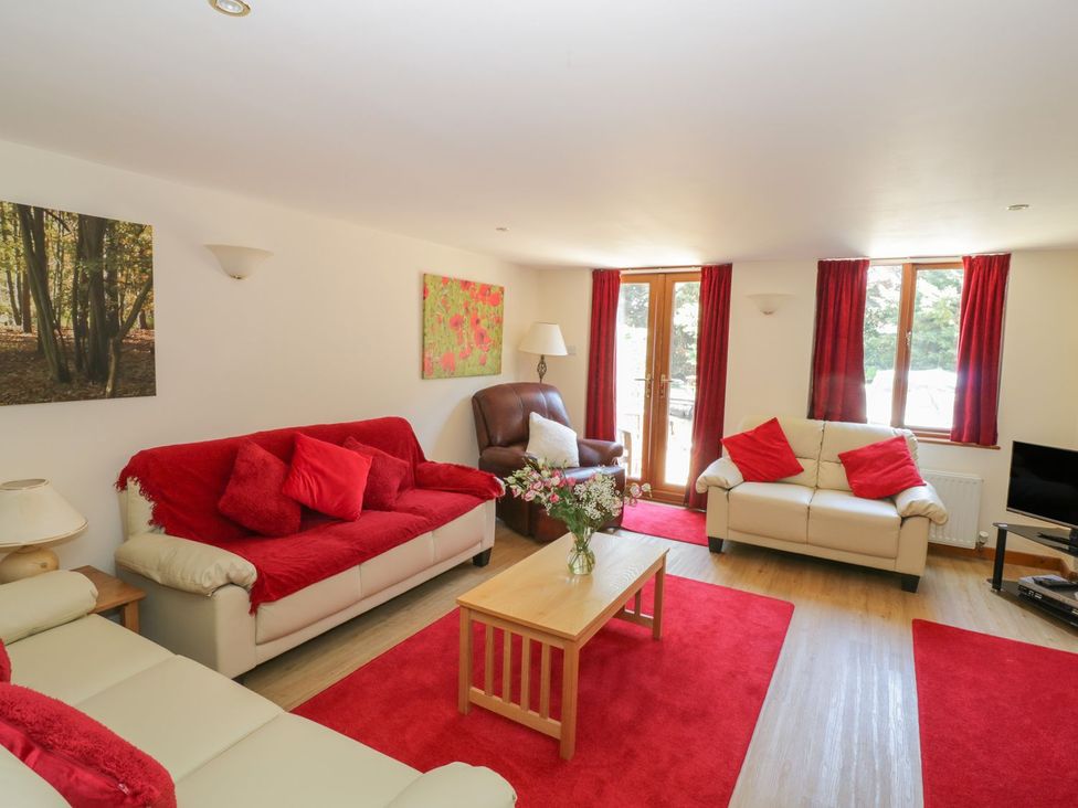 A living room with two sofas and an armchair at Heron Cottage