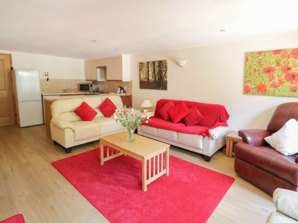 A living room with a sofa and coffee table at Heron Cottage