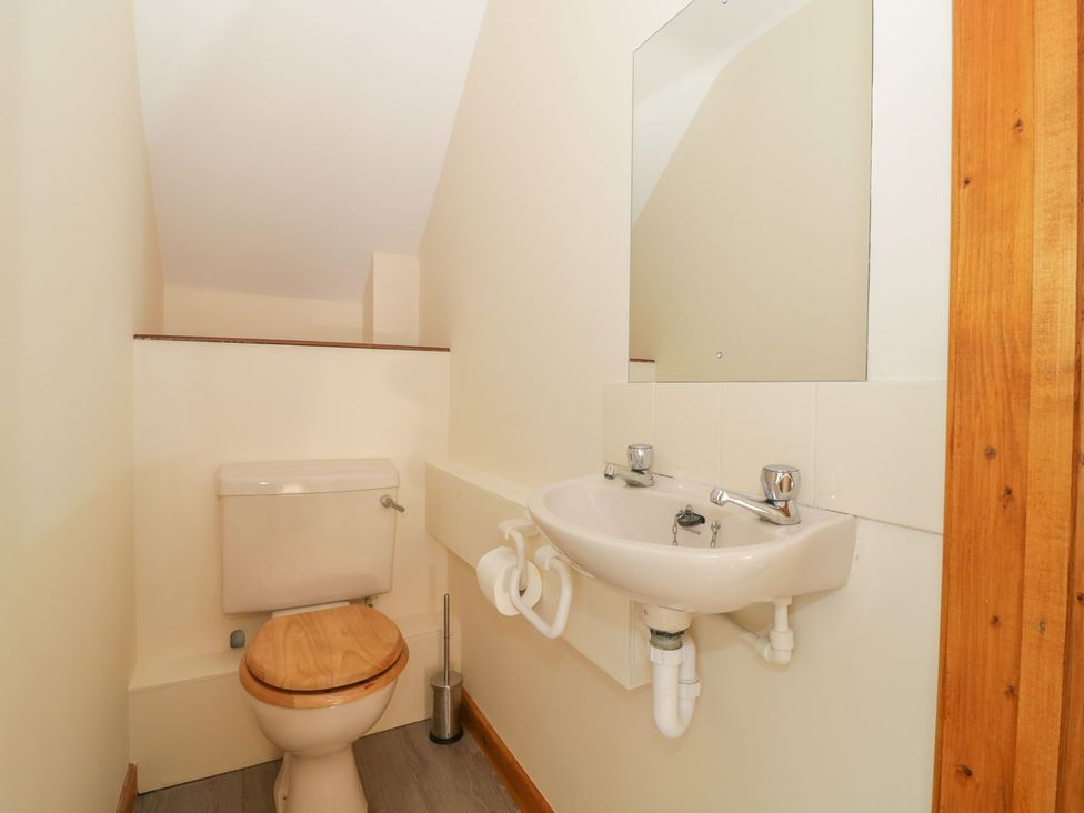 A bathroom with a toilet and sink at Heron Cottage