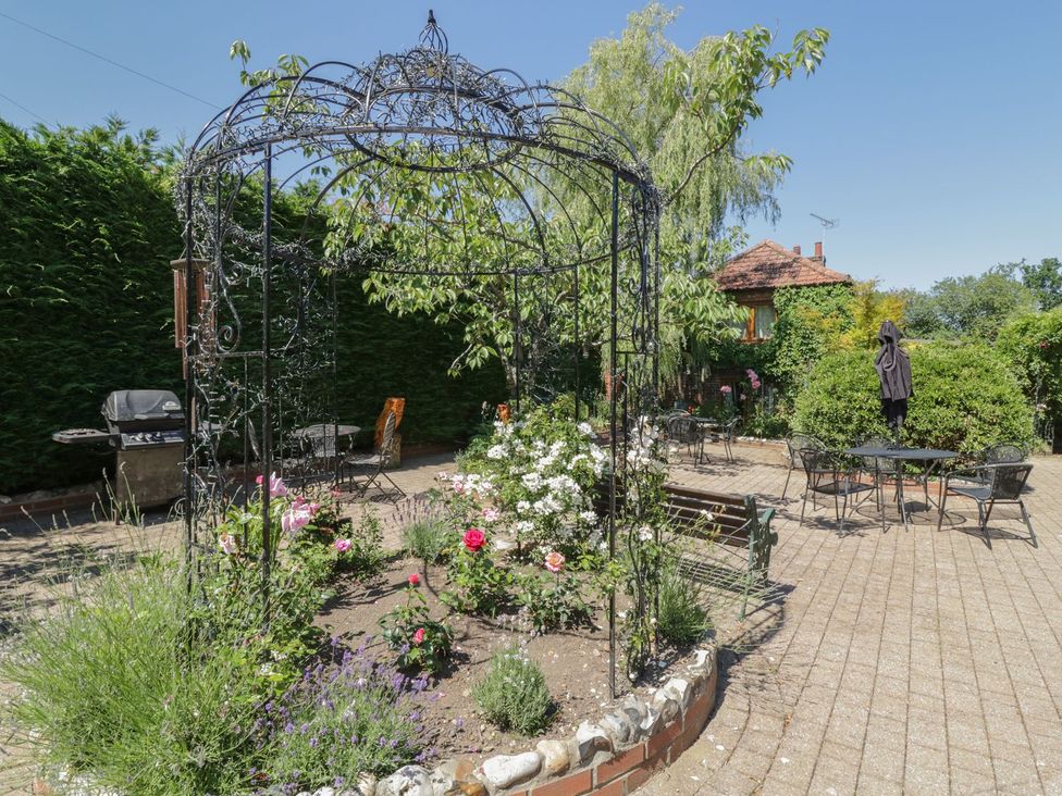 A garden with a decorative gazebo and outdoor seating at Heron Cottage 
