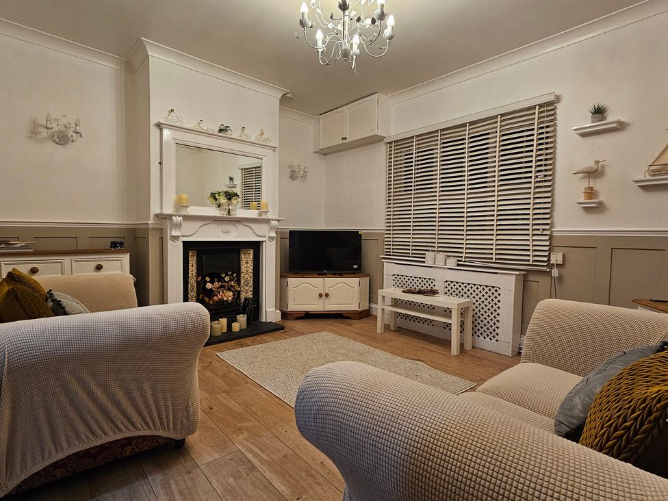 A living room with a fireplace and television at Twisted Chimney View in Alford