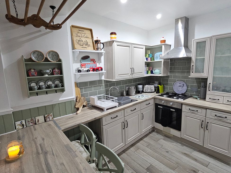 A kitchen with wall shelves and appliances at Twisted Chimney View in Alford