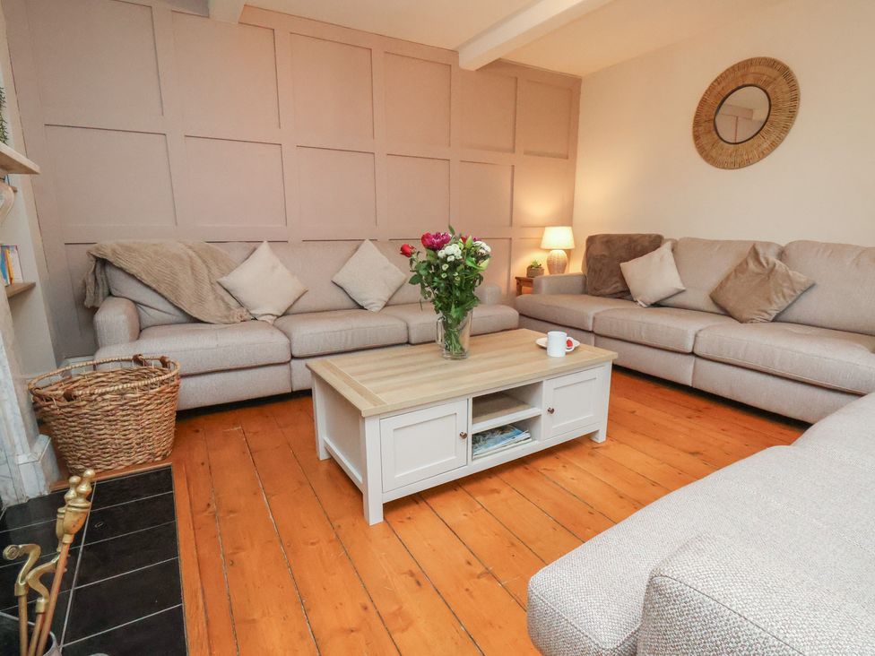 A living room with a coffee table and flowers in a vase at Manor Farmhouse in Reighton near Filey