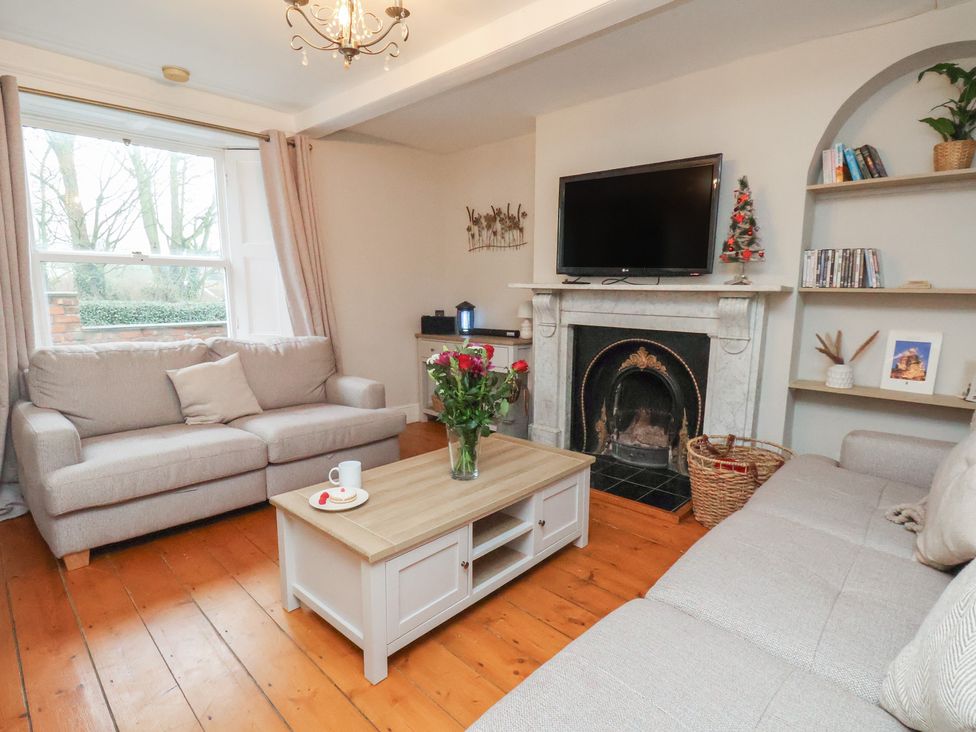 A living room with a sofa and coffee table at Manor Farmhouse in Reighton near Filey