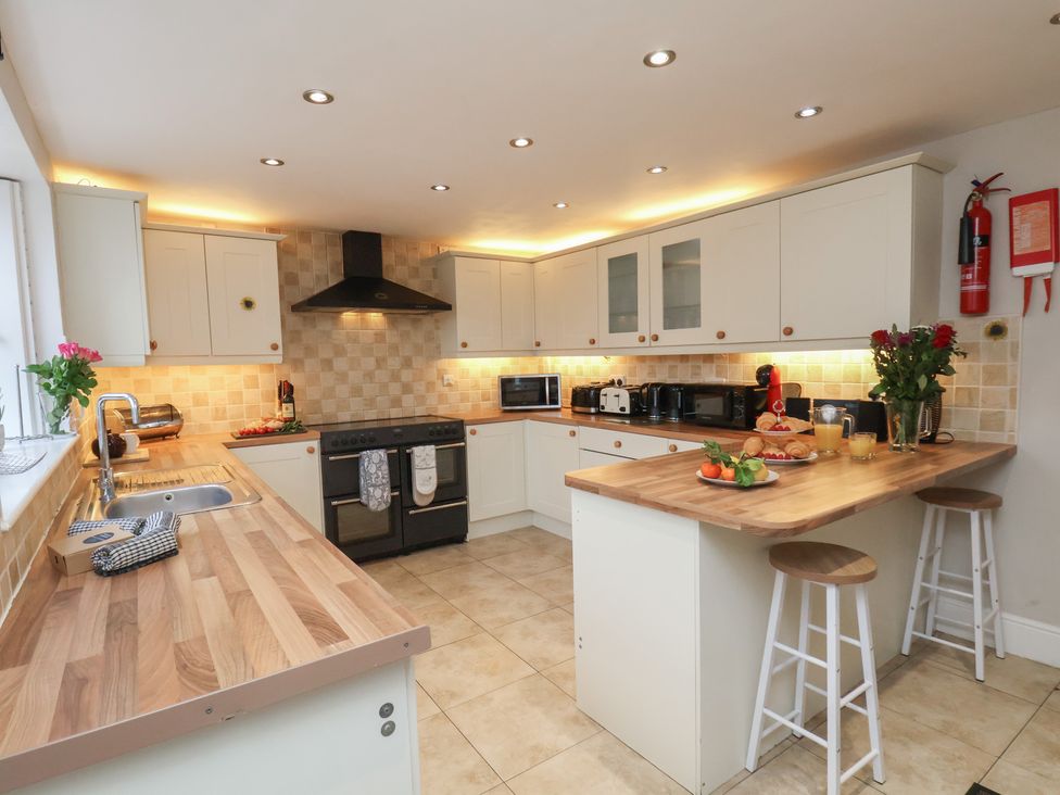 A kitchen with cabinets and appliances at Manor Farmhouse in Reighton near Filey