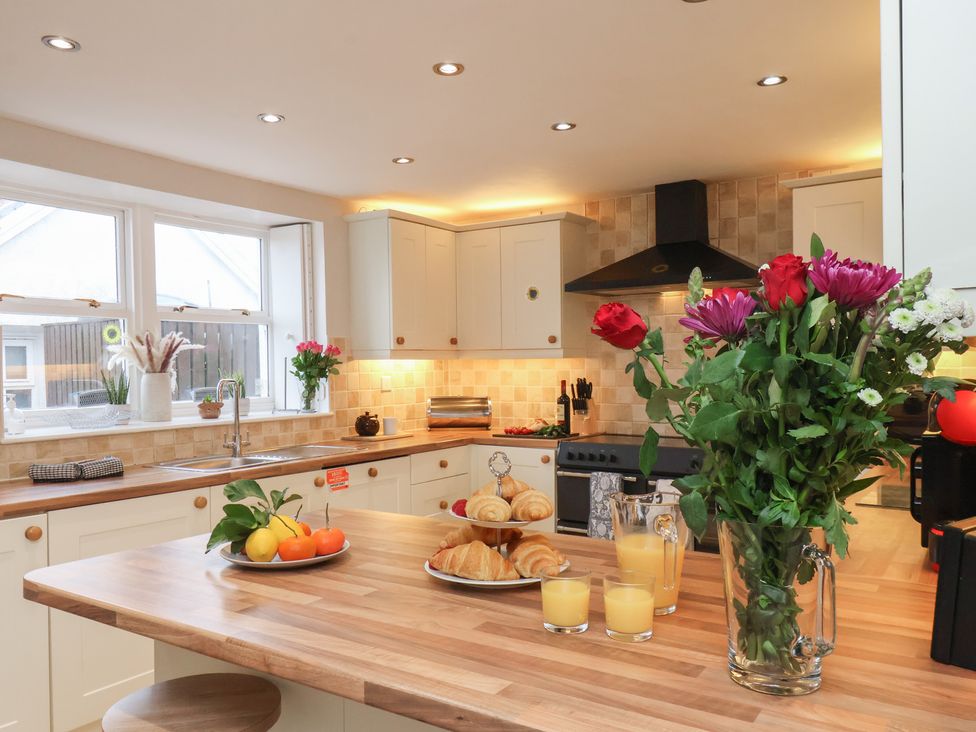 A kitchen featuring a table with fruit and flowers at Manor Farmhouse Reighton near Filey