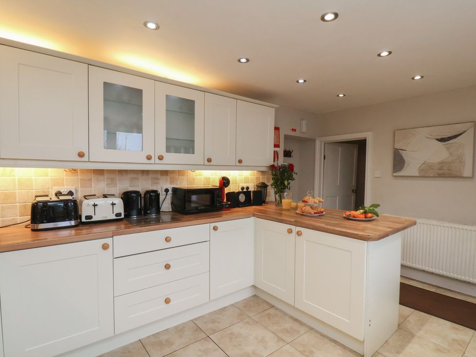A kitchen with cabinets and appliances at Manor Farmhouse in Reighton near Filey