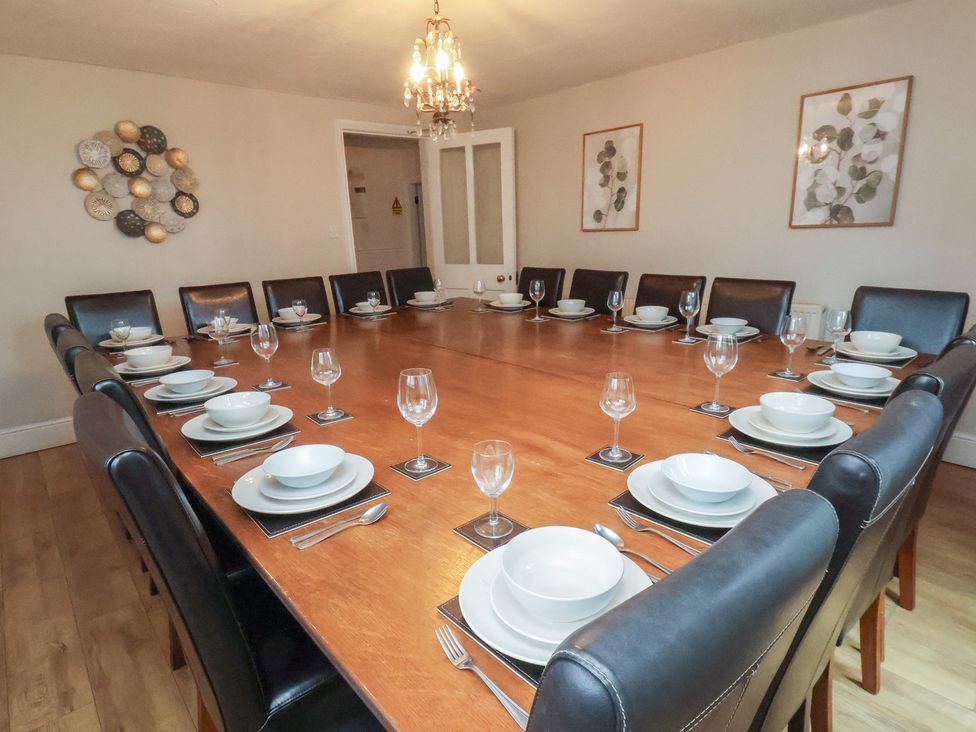 A dining room with a large table set for meals at Manor Farmhouse in Reighton near Filey
