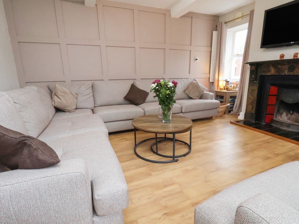 A living room with a sofa and coffee table at Manor Farmhouse in Reighton near Filey