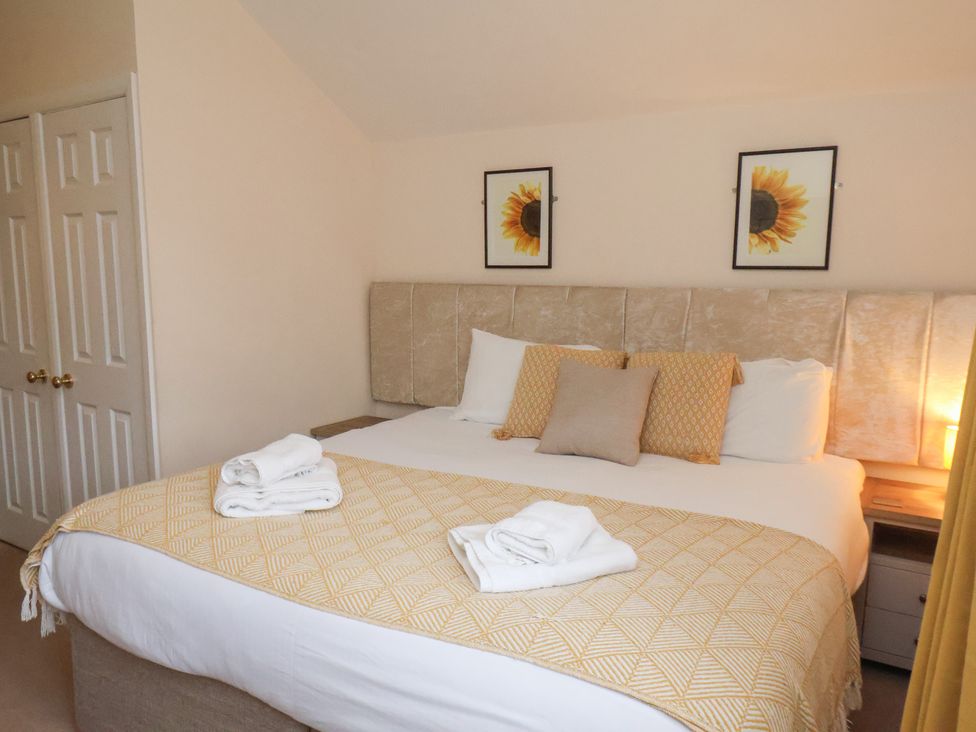 A bedroom with a bed and wall art at Manor Farmhouse Reighton near Filey