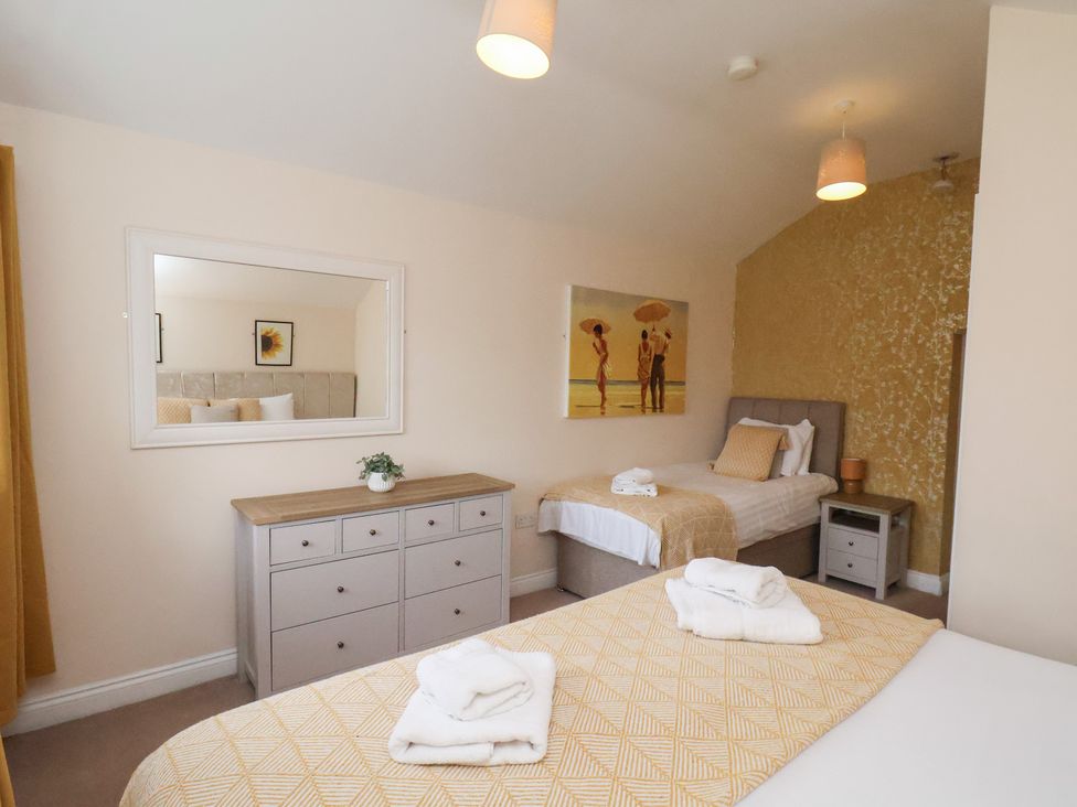 A bedroom with two beds and a dresser at Manor Farmhouse in Reighton near Filey