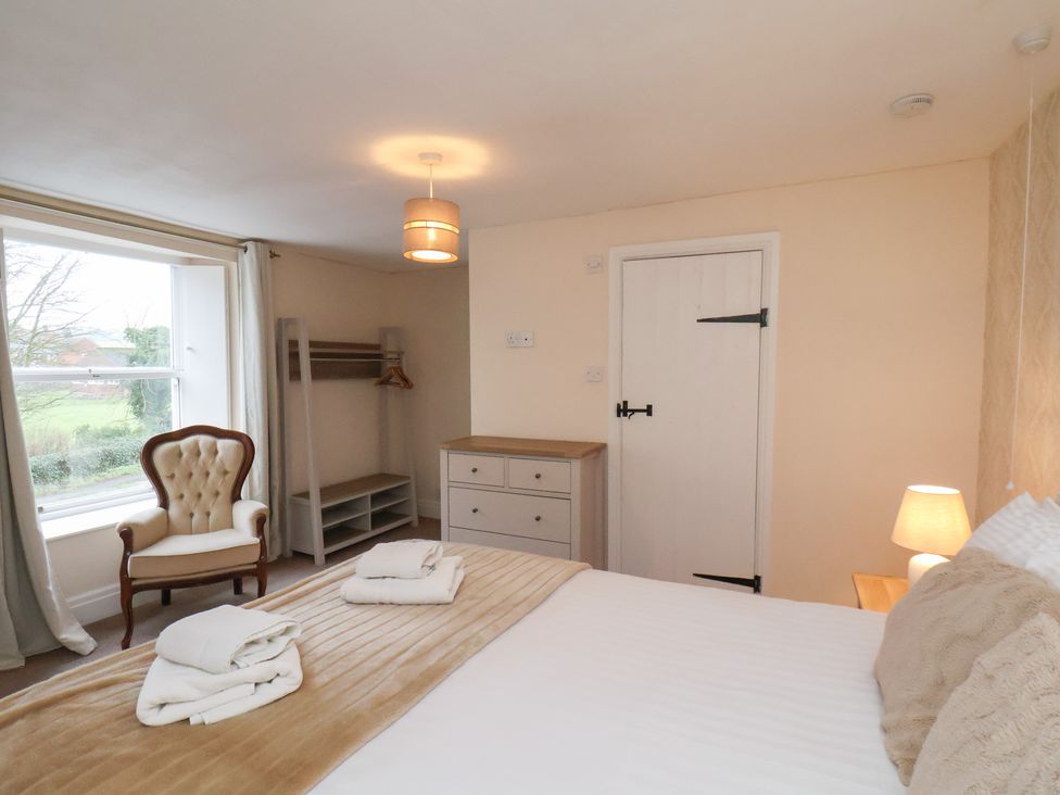 A bedroom with a bed and window at Manor Farmhouse in Reighton near Filey