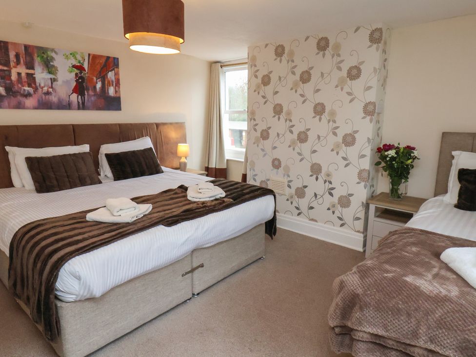 A bedroom with two beds and a vase of flowers at Manor Farmhouse Reighton near Filey