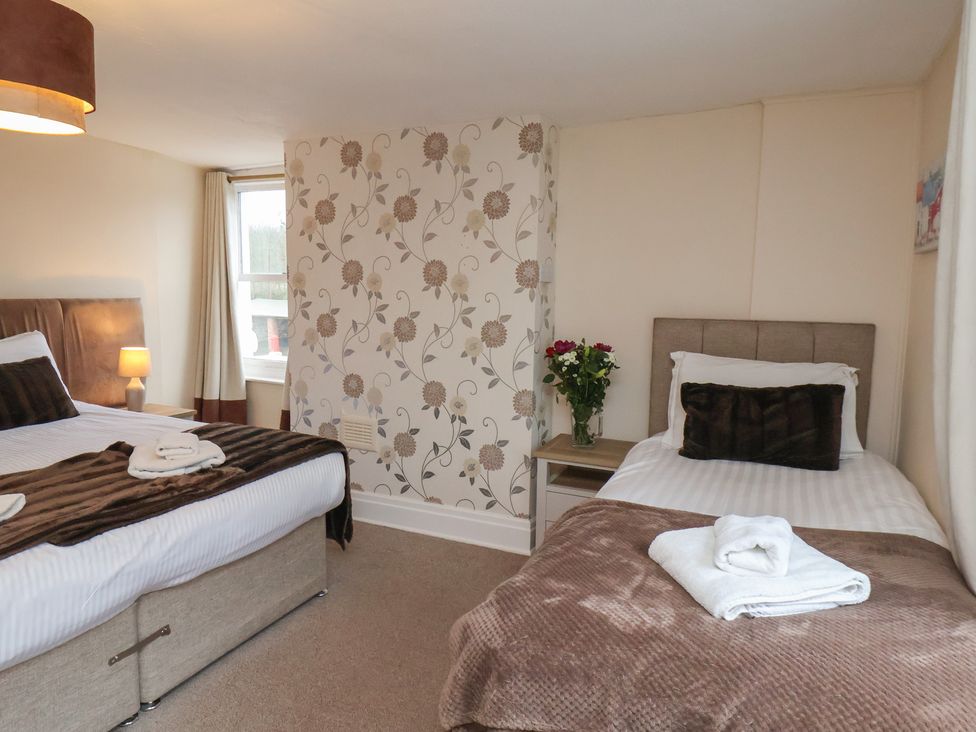 A bedroom with a double bed and single bed at Manor Farmhouse in Reighton near Filey