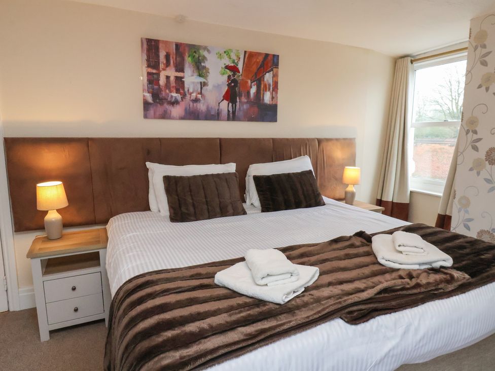 A bedroom with a bed and side table at Manor Farmhouse in Reighton near Filey