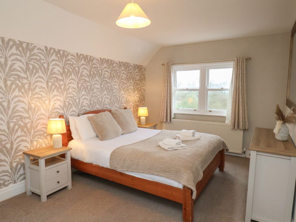 A bedroom with a bed and nightstands at Manor Farmhouse in Reighton near Filey