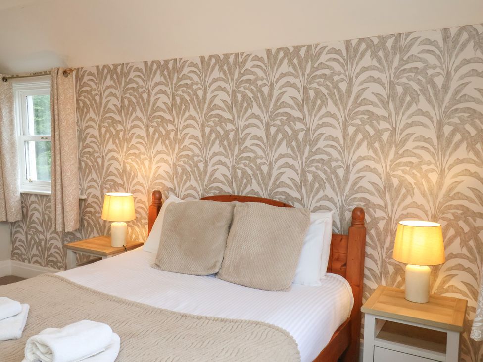A bedroom with a bed and lamps at Manor Farmhouse in Reighton near Filey