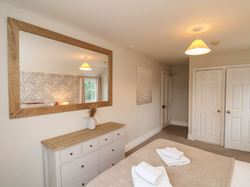A bedroom with a mirror and chest of drawers at Manor Farmhouse in Reighton near Filey