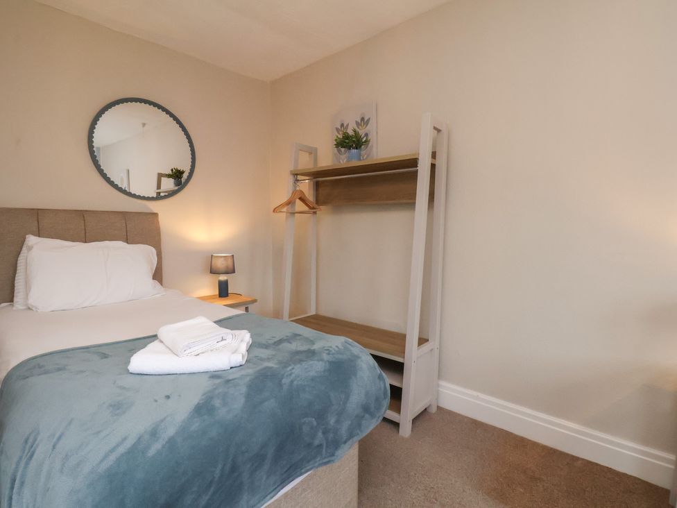 A bedroom with a bed and shelf at Manor Farmhouse in Reighton near Filey