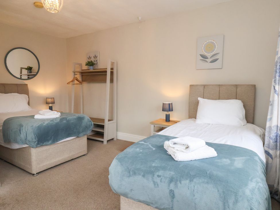 A bedroom with two beds and a mirror at Manor Farmhouse in Reighton near Filey